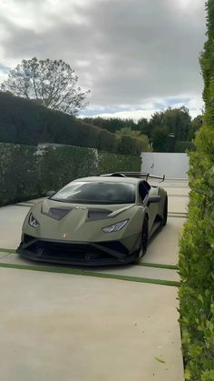 a grey sports car is parked in the driveway