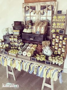 a table topped with lots of cupcakes and cakes next to a window filled with teddy bears