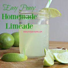 a mason jar filled with lemonade next to limes