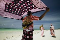 a woman holding an umbrella on the beach