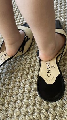 a person wearing black and white shoes standing on a rug