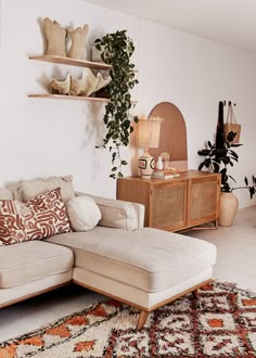 a living room filled with furniture and lots of pillows on top of a white rug