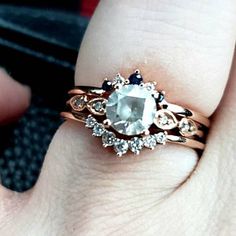 a close up of a person's hand holding a ring with an aqua blue stone