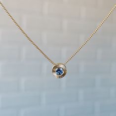 The Aurora Slide Necklace is a shining, luxe beam of light surrounding a pool of rich denim blue Montana sapphire. The hand-engraved lines reflect its shimmering radial pattern, and the center stone is carefully chosen for its captivating color and sparkle. The pendant floats on a smooth curb chain, ideal for stacking on additional Aurora pendants or charms. The Aurora necklace is a stunning beam of sunlight, hung around your neck. Product Details .15ct (3mm) Medium Denim Blue Montana Sapphire 1 Sapphire Round Pendant Necklace With Diamond Cut, Sapphire Necklace With Diamond Cut Round Pendant, Modern Blue Diamond Cut Jewelry, Sapphire Jewelry With Tension Setting, Modern Blue Diamond Necklace, Aurora Necklace, Hand Carved Jewelry, Radial Pattern, Beam Of Light