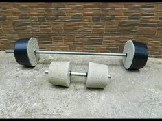 there are two large metal wheels on the ground next to a brick wall, and one is black