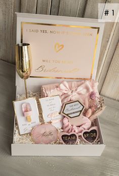 a gift box with pink and gold items in it