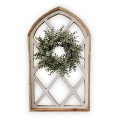 an arched window with a wreath hanging on the front and side panels, made out of wood