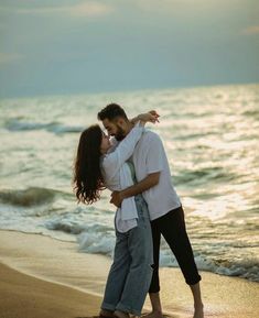 a man and woman embracing on the beach