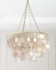 a chandelier hanging from the ceiling with lots of circles and chains on it