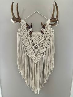 a white wall hanging with antlers on it