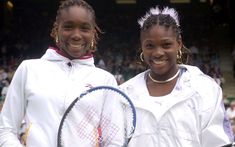 two women standing next to each other holding tennis racquets