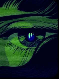 an image of a woman's eye with blue and green light in the iris