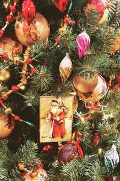 a christmas tree with ornaments on it and a photo hanging from the top of it