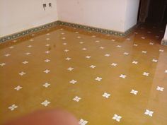 an empty room with tile flooring and white crosses painted on the floor in different colors