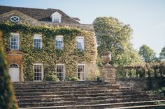 an old building with ivy growing on it's walls and steps leading up to the front door