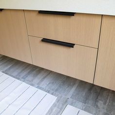 a kitchen with wooden cabinets and white rugs