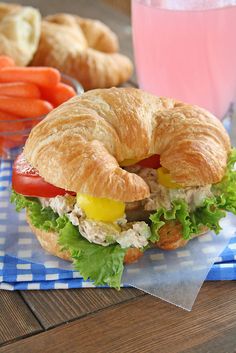 a croissant sandwich with lettuce, tomato, and cheese on it