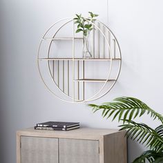 a white shelf with a plant in it next to a potted plant