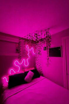 a bed in a room with pink lights on the wall and plants growing from the ceiling