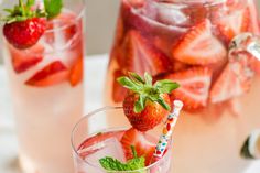 two glasses with strawberries in them on a table