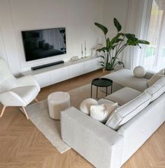 a modern living room with white furniture and wood flooring