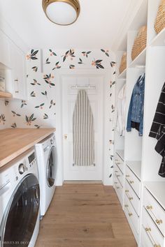 a washer and dryer in a room with wallpaper on the walls behind them