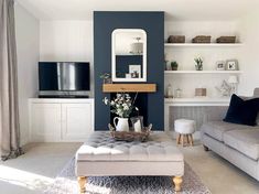 a living room filled with furniture and a fire place next to a wall mounted tv