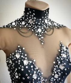 a black dress with silver and white beads on it