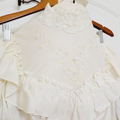 a white wedding dress is hanging on a hanger