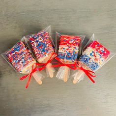 four lollipops wrapped in cellophane and tied with red white and blue ribbon