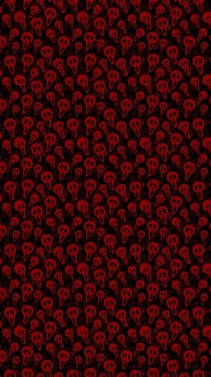 a red and black wallpaper with skulls on it's face, in the middle of