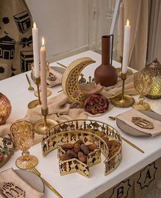 a table topped with candles and plates filled with food