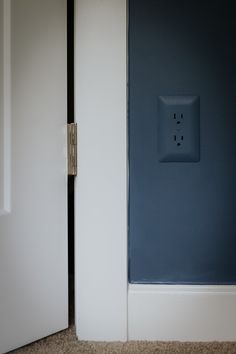 an electrical outlet in the corner of a room with blue paint on the walls and floor