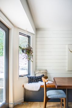 a dining room table with a bench and window