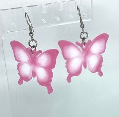 Beautiful, handmade holographic pink and white dangle butterfly earrings, made with resin and stainless steel. Pink Butterfly Charm Earrings, Pink Butterfly Charm Drop Earrings, Trendy Pink Butterfly Charm Jewelry, Handmade Pink Butterfly Earrings, Pink Butterfly Earrings With Ear Wire, Pink Drop Earrings With Butterfly Charm, Trendy Pink Jewelry With Butterfly Charm, Trendy Pink Butterfly Jewelry, Pink Butterfly Charm Earrings As Gift