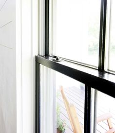 an open sliding glass door on the outside of a house with white walls and wood flooring