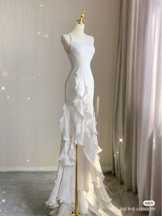 a white dress on a mannequin in front of a curtained room with curtains