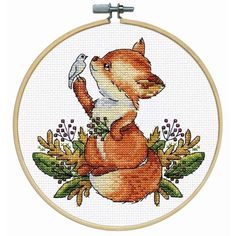 a cross stitch pattern with a fox holding a bird