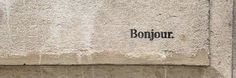 the word bonjou written in black on a stone wall