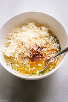 a white bowl filled with soup and cheese