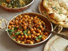 there are many different types of food in bowls on the table with utensils