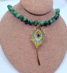 I used a Vintage brooch to make this beautiful Peacock feather necklace.  The beads are jade in different greens which are strung on hand knotted silk.  The feather itself is big and colorful and really sparkles.  You will love this necklace.  The quality is there and you won't be seeing it on anyone else. I specialize in Vintage sterling jewelry and do my best to bring you pieces you will not see anywhere else. Back to my shop, where you will find more Vintage jewelry of all categories, including my Brutalist section, the unique necklaces I make with Vintage components, and my own one-of-a-kind watercolors https://www.etsy.com/shop/JanEleven Elegant Green Necklace With Peacock Design, Green Peacock Design Necklace As A Gift, Green Peacock Design Jewelry Gift, Green Beaded Jewelry For Mardi Gras, Handmade Green Jewelry For Mardi Gras, Peacock Feather Pendant, Peacock Necklace, Beautiful Peacock, Feather Necklace