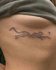 a woman's lower back with a cheetah tattoo on it