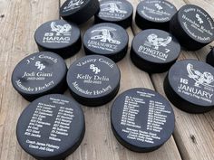 many different types of hockey pucks sitting on a wooden table with the names of each team