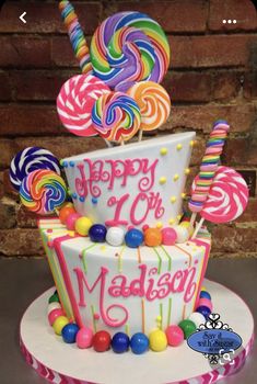 a birthday cake decorated with candy and lollipops