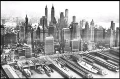 an aerial view of the new york city skyline in black and white, with boats on the water