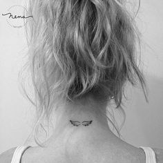 a woman's back neck with a small butterfly tattoo on the left side of her neck