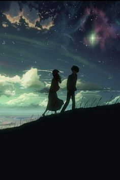 two people standing on top of a hill looking at the stars in the night sky