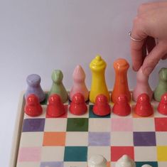 a close up of a person playing a game of checkers on a chess board