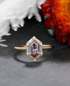 an engagement ring with a pink tourmaline stone surrounded by white and yellow diamonds